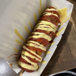 Seoul Stick signature dishes Korean Corn Dogs (with various coatings like potato or ramen), Tteok-bokki (spicy rice cakes), Skewers (e.g., chicken, sausage), Kimchi Fries.